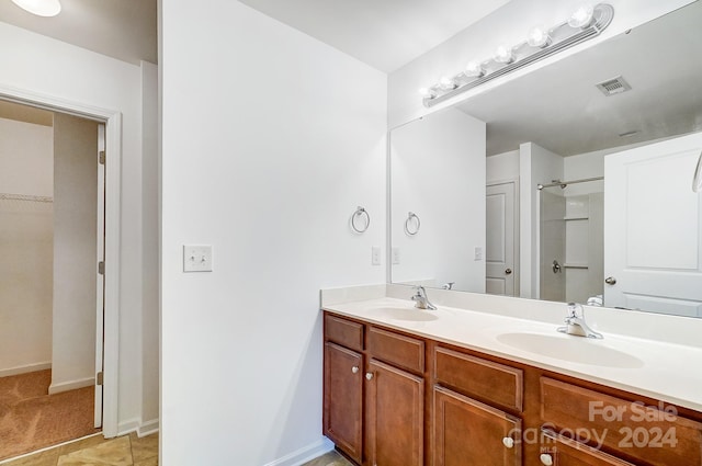 bathroom with tile patterned floors, a shower, and vanity