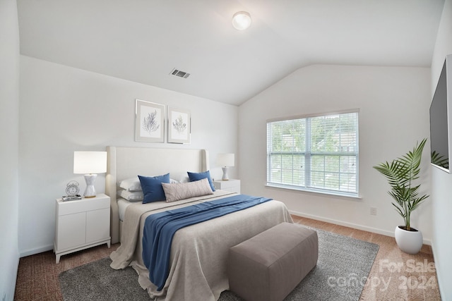 carpeted bedroom with lofted ceiling