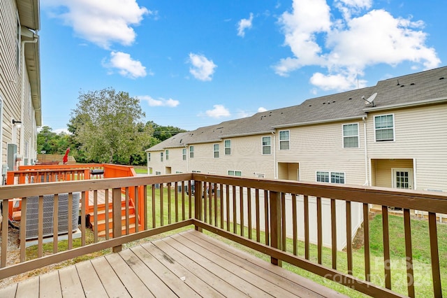 wooden deck featuring a lawn