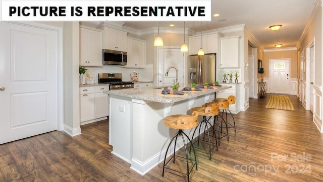 kitchen featuring appliances with stainless steel finishes, dark wood-type flooring, an island with sink, and white cabinets