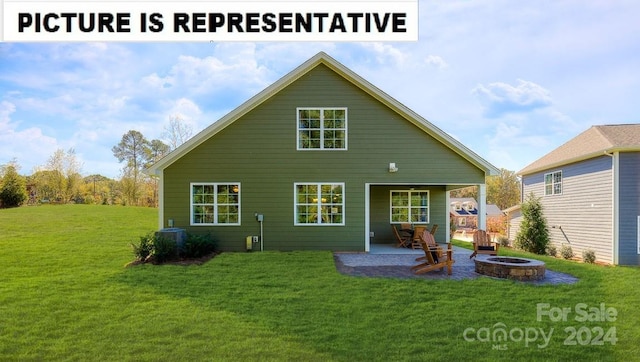 rear view of property with a fire pit, a yard, and a patio area