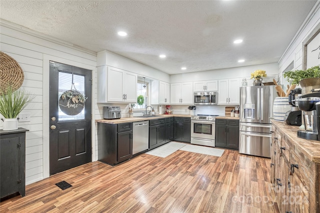 kitchen featuring white cabinetry, a healthy amount of sunlight, and stainless steel appliances