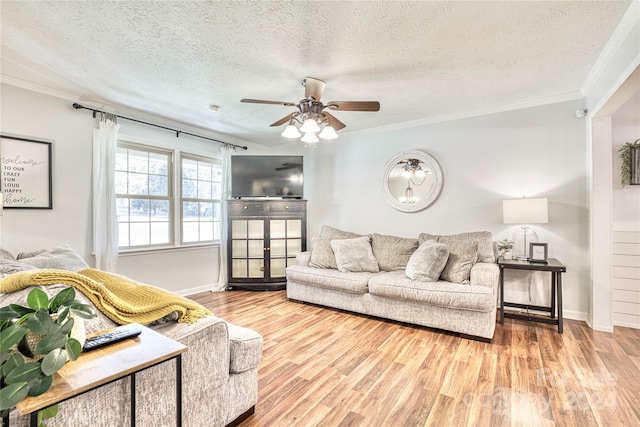 living room featuring ornamental molding, light hardwood / wood-style flooring, a textured ceiling, and ceiling fan