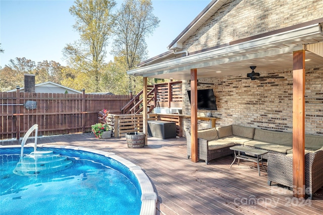 view of swimming pool featuring a wooden deck, ceiling fan, and an outdoor living space