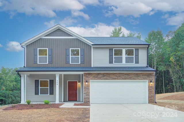 front of property featuring covered porch and a garage