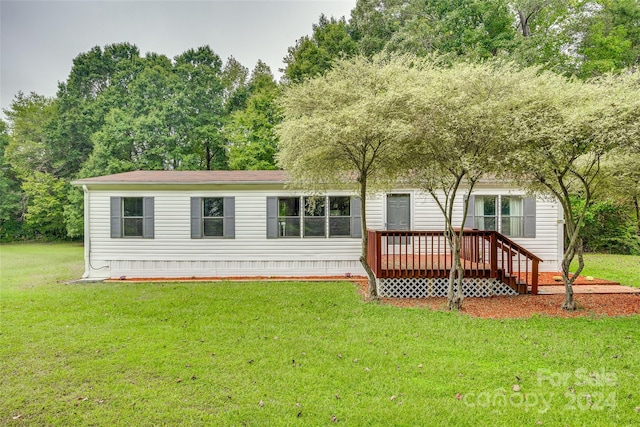 back of house featuring a lawn and a deck