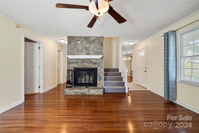 unfurnished living room with ornamental molding, wood-type flooring, ceiling fan, and a textured ceiling