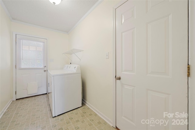 washroom with a textured ceiling, washer and clothes dryer, and ornamental molding