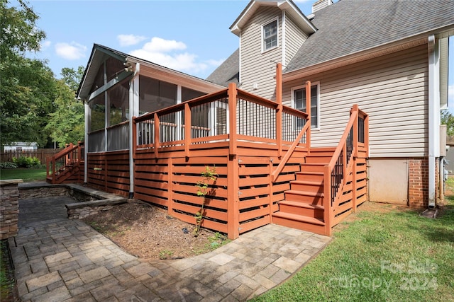 exterior space featuring a sunroom, a patio area, and a deck