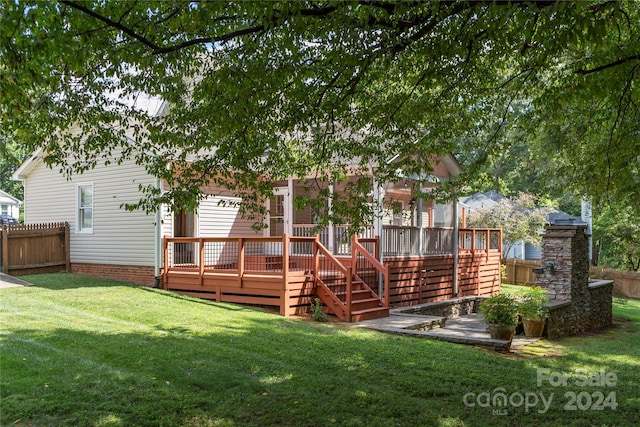 rear view of house featuring a deck and a yard