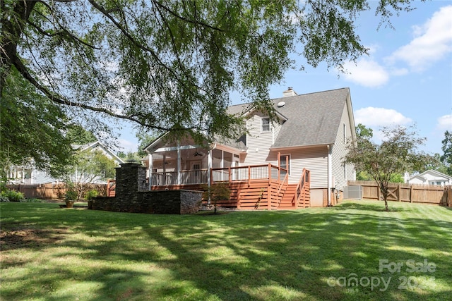 rear view of property with a yard and a deck