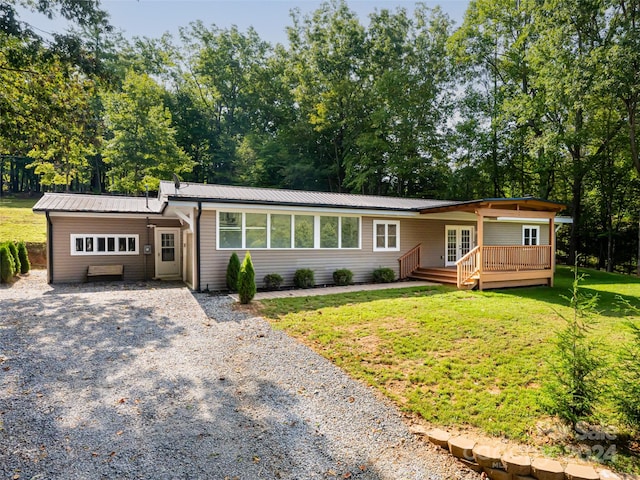 view of front of home with a wooden deck and a front lawn