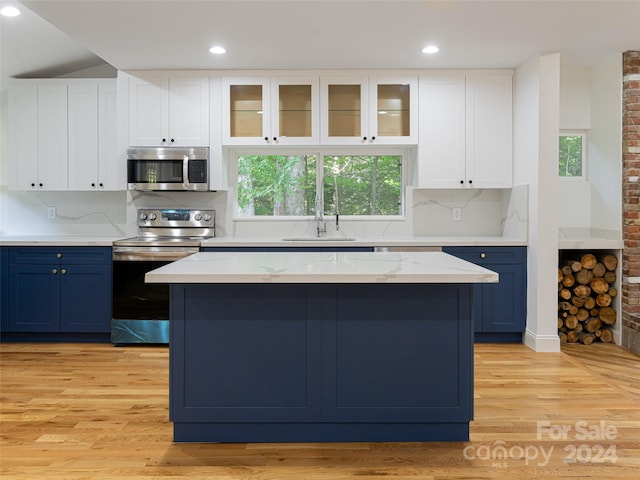 kitchen featuring appliances with stainless steel finishes, a healthy amount of sunlight, blue cabinets, and sink