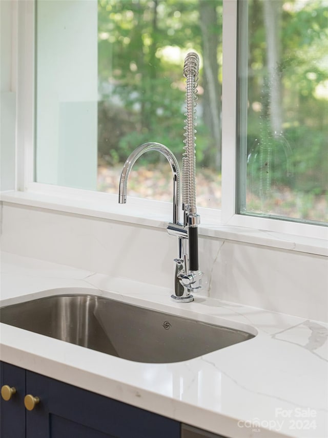 room details with light stone countertops and sink