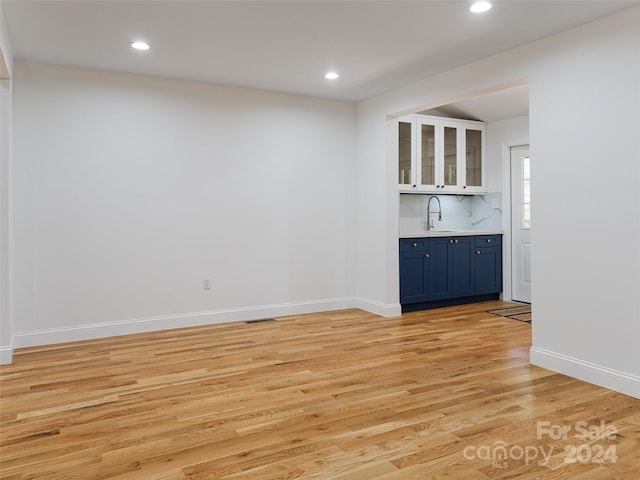 spare room featuring light hardwood / wood-style floors and indoor bar