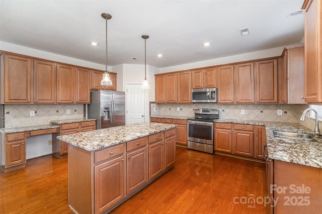 kitchen with sink, decorative light fixtures, dark hardwood / wood-style floors, a kitchen island, and stainless steel appliances