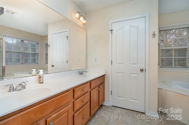 bathroom with vanity and a washtub