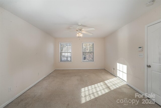 empty room with ceiling fan and light carpet