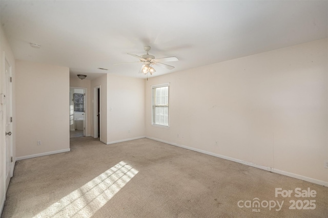 spare room with ceiling fan and light colored carpet