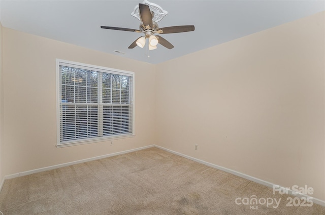 carpeted spare room with ceiling fan