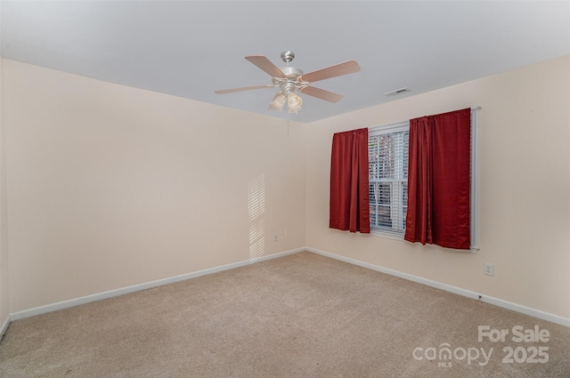 spare room featuring light colored carpet and ceiling fan