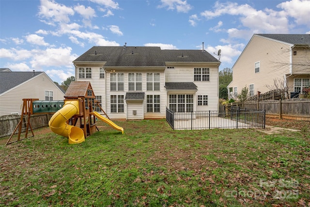 back of house with a yard, a patio, and a playground