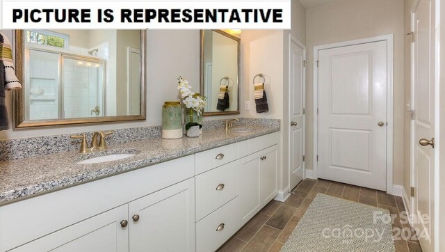 bathroom featuring an enclosed shower and vanity