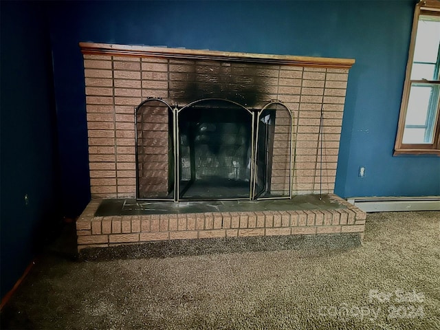 room details featuring carpet flooring, a baseboard radiator, and a fireplace