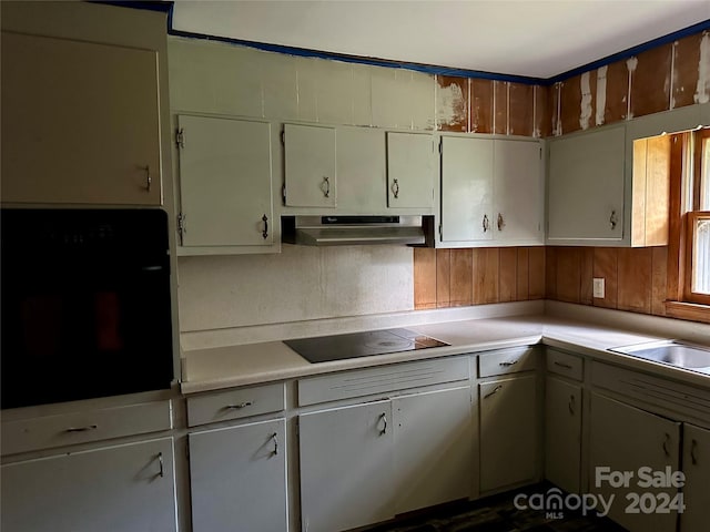 kitchen with sink, black appliances, and white cabinetry