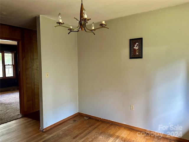 spare room featuring hardwood / wood-style flooring and wooden walls