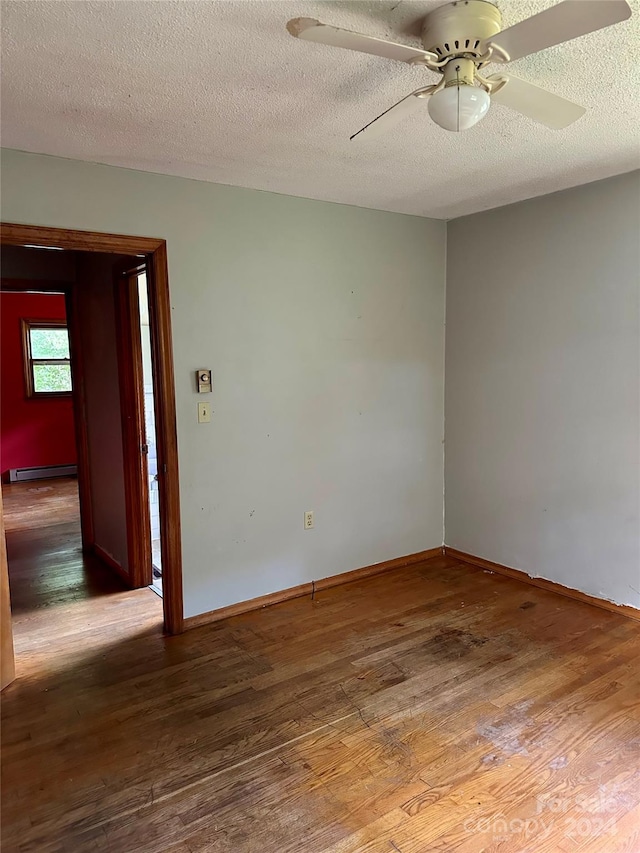 spare room featuring baseboard heating, a textured ceiling, hardwood / wood-style flooring, and ceiling fan