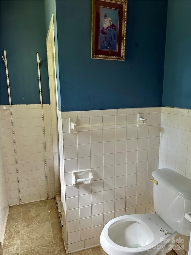 bathroom featuring tile walls and toilet