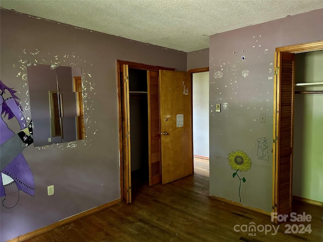 interior space with dark wood-type flooring and a textured ceiling