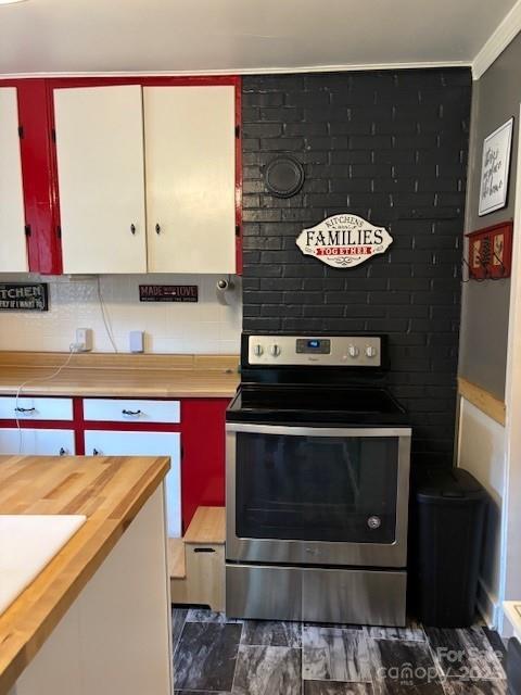 kitchen featuring electric stove, butcher block countertops, and crown molding