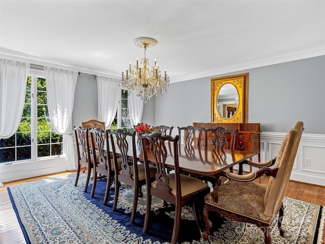 dining room featuring ornamental molding, hardwood / wood-style floors, and a notable chandelier