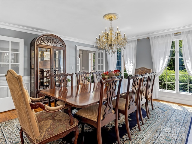 dining room with ornamental molding, a notable chandelier, and hardwood / wood-style floors