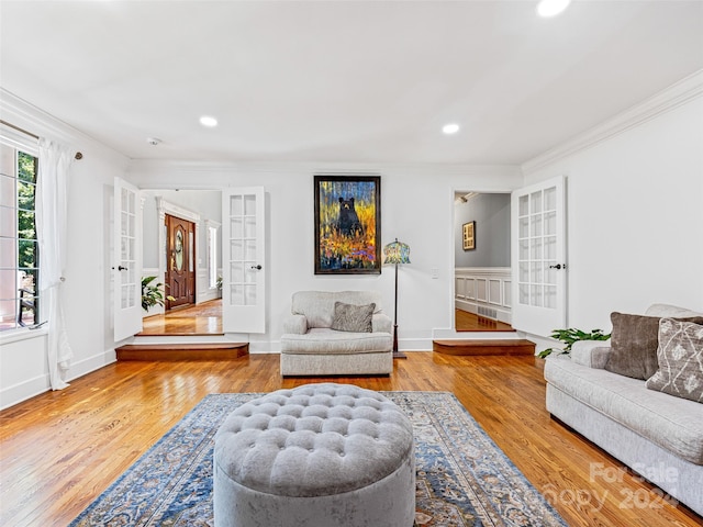 living room with french doors, light hardwood / wood-style flooring, and crown molding