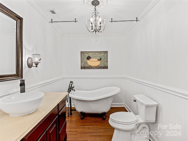 bathroom featuring wood-type flooring, a washtub, crown molding, vanity, and toilet