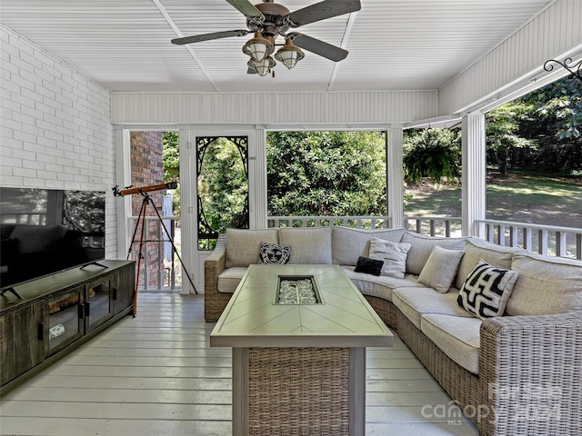 sunroom featuring ceiling fan and plenty of natural light