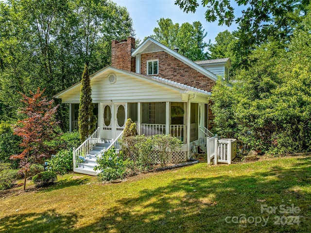 back of property with a porch and a yard