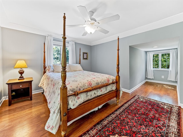 bedroom featuring multiple windows, ceiling fan, and hardwood / wood-style flooring