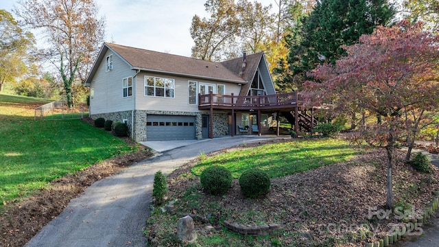 view of front of property featuring a front lawn, a deck, and a garage