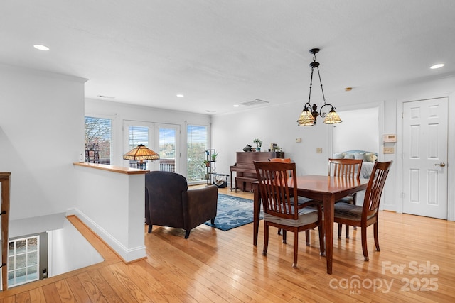 dining room with light hardwood / wood-style floors and crown molding