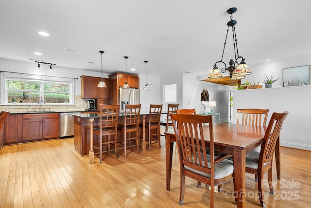 dining room with light hardwood / wood-style flooring, a chandelier, and sink