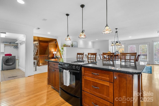 kitchen with electric range, a center island, french doors, hanging light fixtures, and light hardwood / wood-style floors