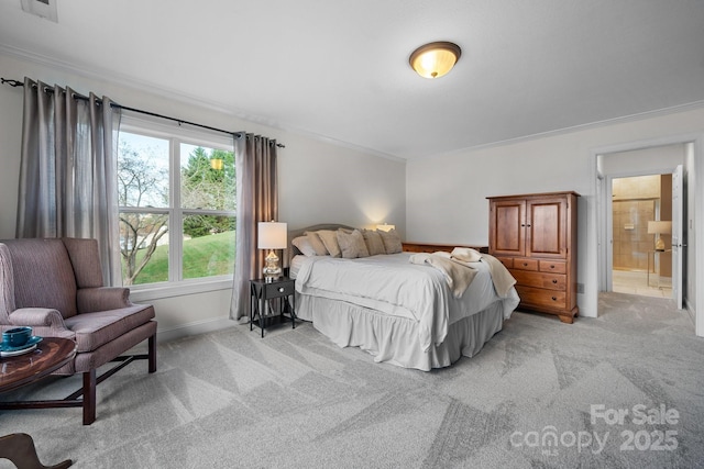 carpeted bedroom with ensuite bath and crown molding