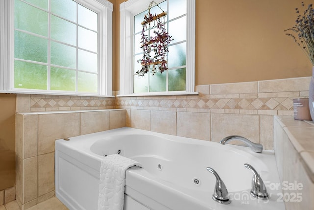 bathroom with a bathtub, a healthy amount of sunlight, and tile walls