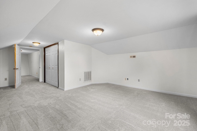 bonus room featuring lofted ceiling and light carpet