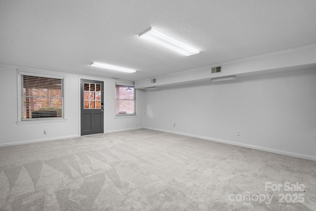 spare room with light carpet and a textured ceiling