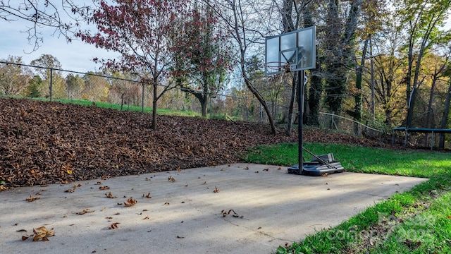 view of patio with basketball hoop and a trampoline